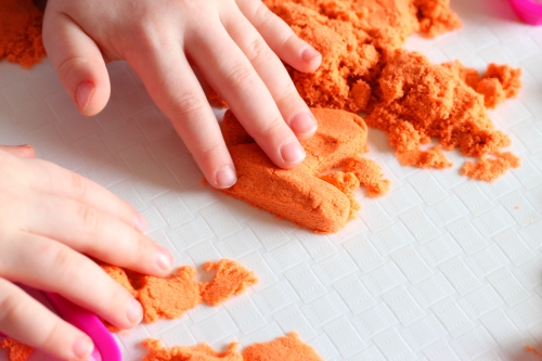 Cut out letter from Kinetic sand with cookie cutter