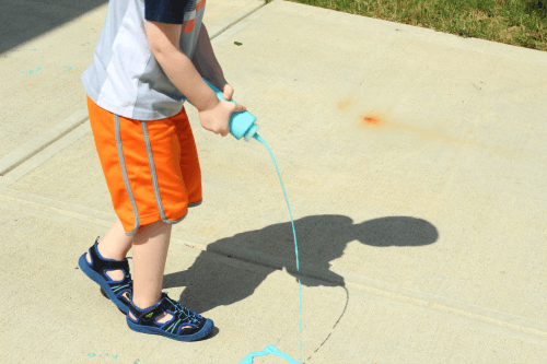 Painting with puffy paint on the sidewalk!