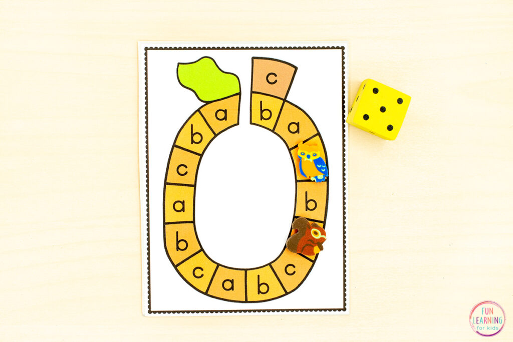 A fun pumpkin theme alphabet activity for kids. Pumpkin shaped mini board game task cards with letters a, b or c on each space. A dice is on the side and two mini erasers are on spaces on the game.